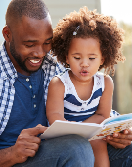 dad reading children's books to daughter